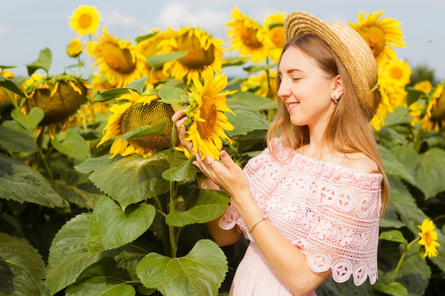 Photo étonnante, belle jeune femme blonde debout parmi les tournesols