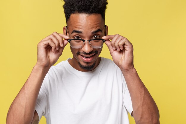 Photo de face d&#39;un beau jeune homme à la peau foncée positif vêtu d&#39;une chemise blanche