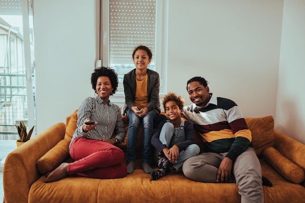 Photo d'une famille regardant la télévision ensemble à la maison