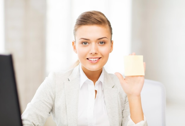 Photo photo d'une femme d'affaires souriante montrant un post-it