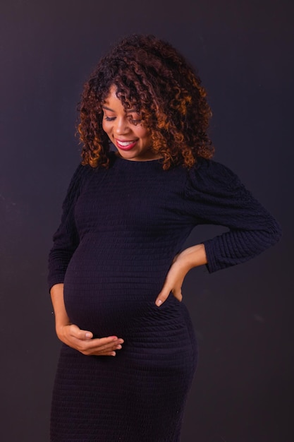 Photo de femme afro-américaine enceinte faite en studio photo avec fond noir