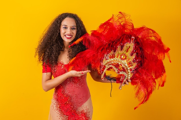 Photo d'une femme afro habillée pour le carnaval en tenue de danseuse tenant sa couronne à la main.