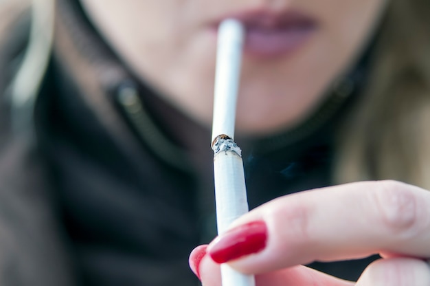 Photo d&#39;une femme allumant sa cigarette