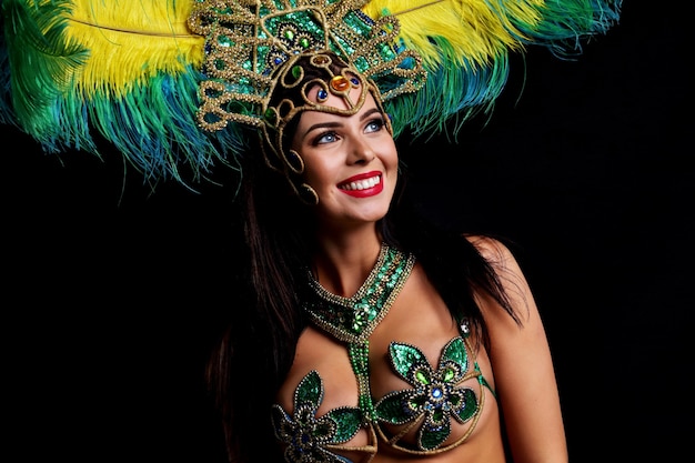 Photo de femme brésilienne posant en costume de samba sur fond noir