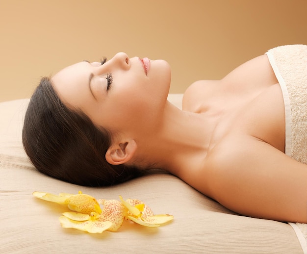 Photo d'une femme dans un salon spa allongé sur le bureau de massage