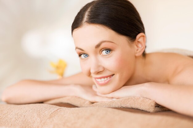 photo de femme dans un salon spa allongée sur le bureau de massage