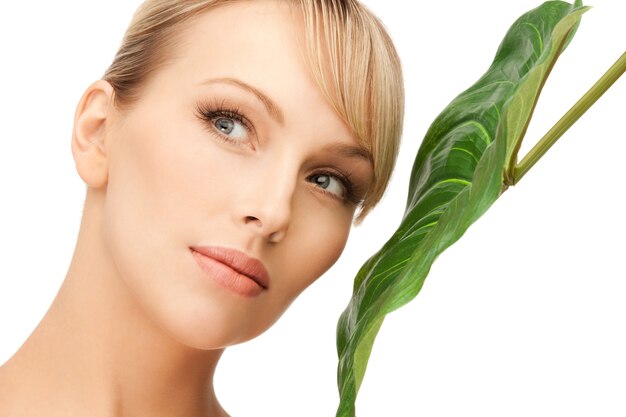 photo de femme avec une feuille verte sur blanc.