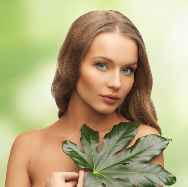 photo de femme avec une feuille verte sur blanc