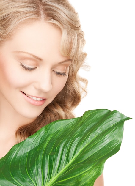 photo de femme avec une feuille verte sur blanc.