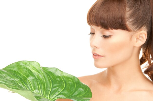 photo de femme avec une feuille verte sur blanc