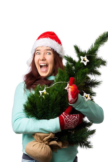 Photo d'une femme heureuse dans un chapeau de Père Noël avec un arbre de Noël