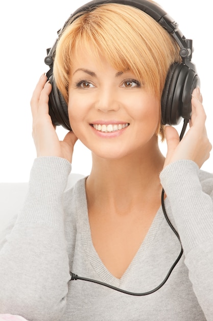 photo de femme heureuse dans les écouteurs over white