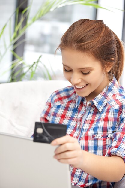 photo de femme heureuse avec ordinateur portable et carte de crédit