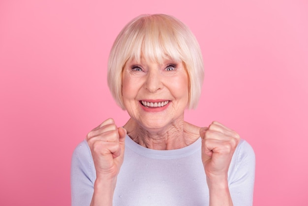 Photo d'une femme mature et gaie, réjouissez-vous de la victoire, du triomphe, de la remise de la victoire, hourra isolé sur un fond de couleur rose