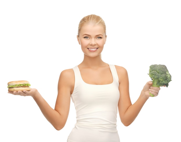 photo de femme sportive avec brocoli et hamburger