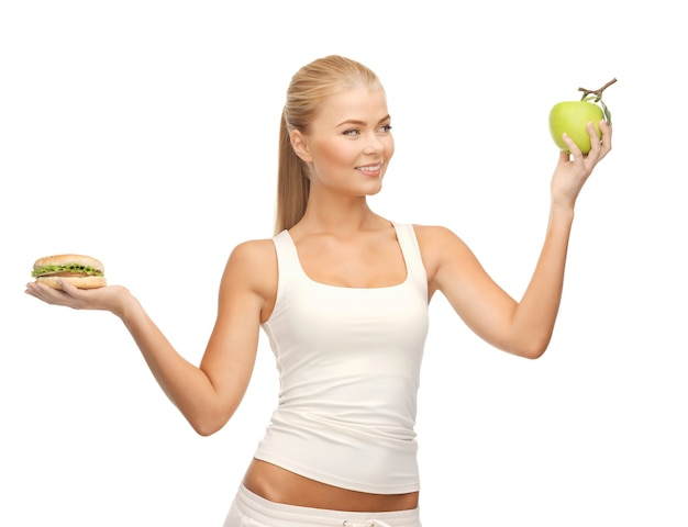 photo de femme sportive avec pomme et hamburger