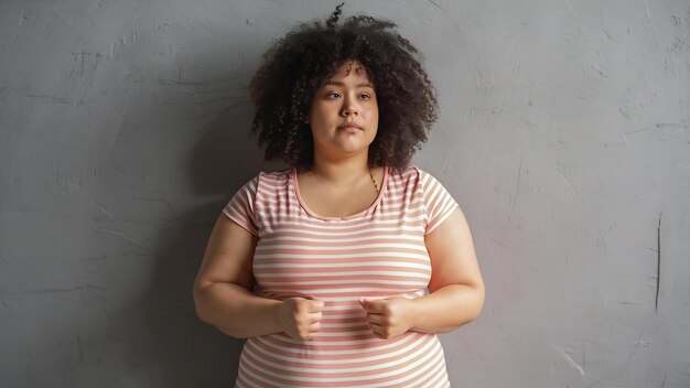 Photo une photo d'une femme en surpoids et obèse sur un mur gris