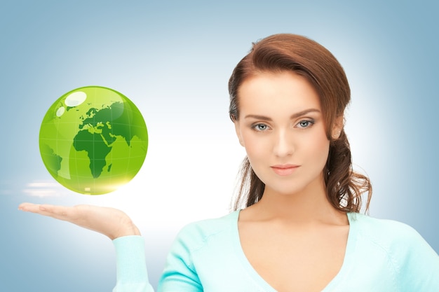 photo de femme tenant un globe vert sur sa main