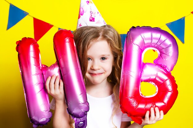 Photo D'une Fille D'anniversaire Avec Des Ballons Sur Un Jaune.