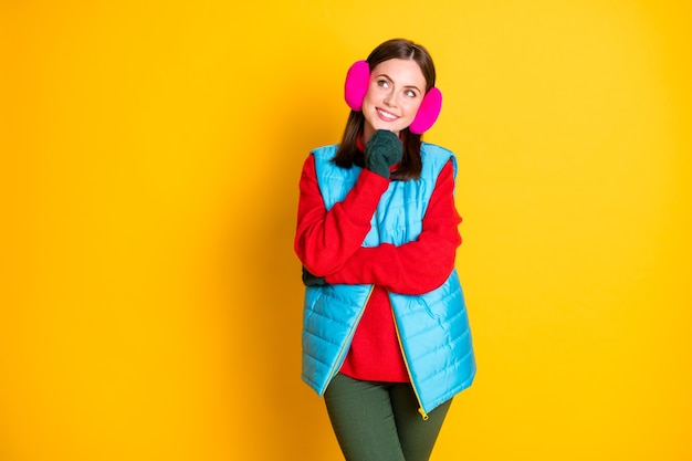 Photo d'une fille intéressée qui touche des mitaines vertes menton regarder copyspace pense que les pensées décident des vacances d'hiver porter un pantalon bleu rose pantalon isolé sur fond de couleur brillant brillant