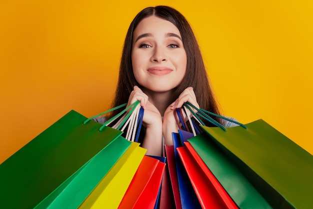 Photo de fille avec des sacs à provisions visage adorable sur fond jaune