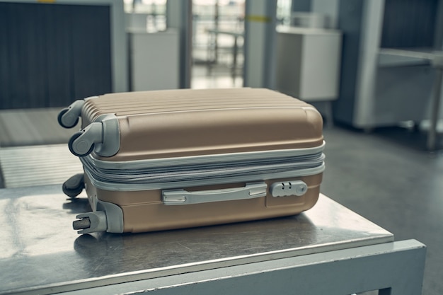 Photo photo focalisée sur des bagages qui reposent sur un support métallique au comptoir d'enregistrement avant de passer à l'avion