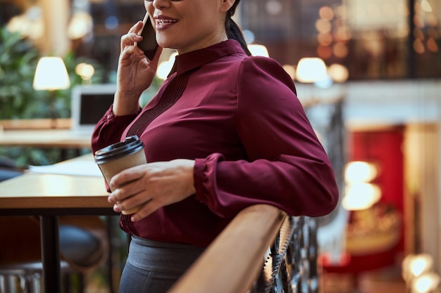 Photo focalisée sur la jeune femme qui s'appuie sur la balustrade