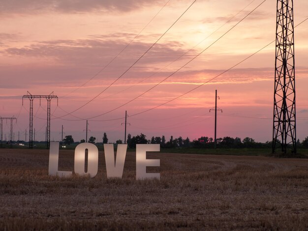 Photo de grandes lettres blanches avec de la mousse sur fond de coucher de soleil dans la nature