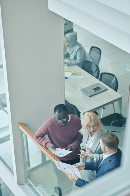 Photo gratuite de jeunes hommes d'affaires peignant et écrivant dans un bureau moderne