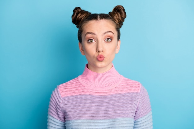 Photo en gros plan d'une adolescente séduisante deux petits pains drôles adorable charmant mignon joli jeune envoyant des baisers aériens petit ami porter un pull rayé chaud décontracté isolé sur fond de couleur bleu