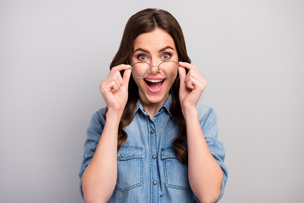 Photo gros plan de la belle femme d'affaires bouche ouverte utiliser de nouvelles lunettes de travail avec ordinateur protéger la vue porter des spécifications jeans décontractés chemise en jean couleur gris isolé