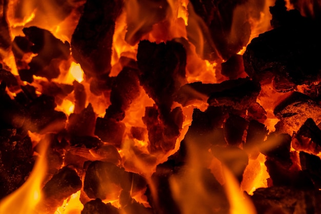La photo en gros plan sur des charbons rouges dans un feu de joie brûlant