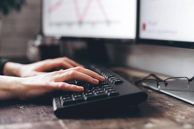 Photo en gros plan d'un clavier d'ordinateur avec les doigts tapant ou travaillant activement sur les boutons Copier l'espace