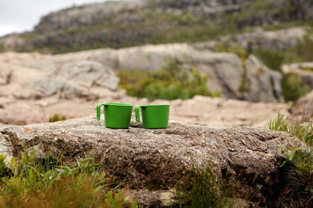 Photo gros plan de deux tasses de thé sur des montagnes floues voir une boisson chaude dans une tasse dans les montagnes