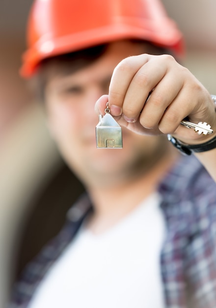 Photo gros plan du contremaître tenant les clés de la nouvelle maison en main