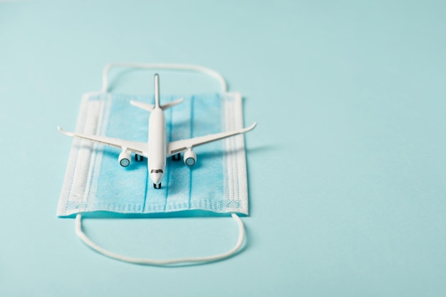 Photo en gros plan du modèle d'avion sur fond bleu isolé de masque médical avec fond