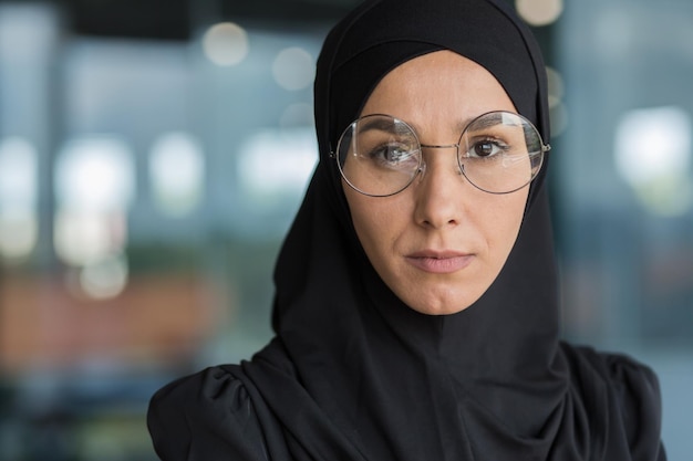 Photo en gros plan d'une femme d'affaires en hijab noir femme musulmane travaillant au travail à l'intérieur d'un bureau moderne