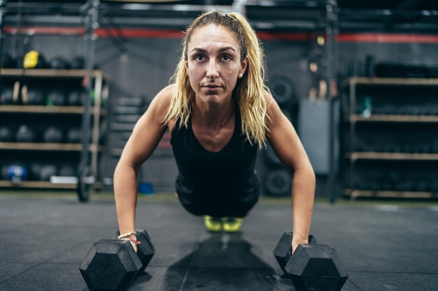 La photo en gros plan d'une femme concentrée faisant des pompes