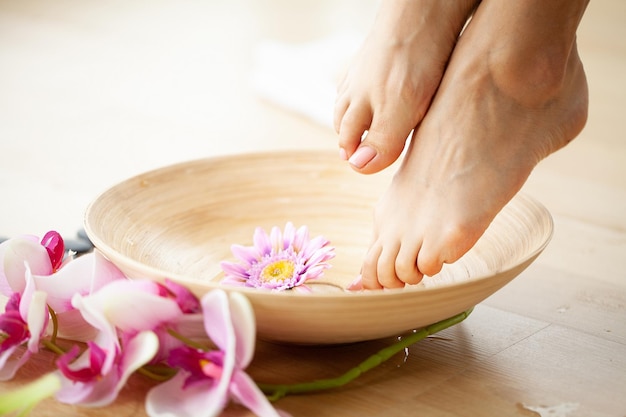 Photo gros plan d'une femme pieds au salon spa sur procédure de pédicure.