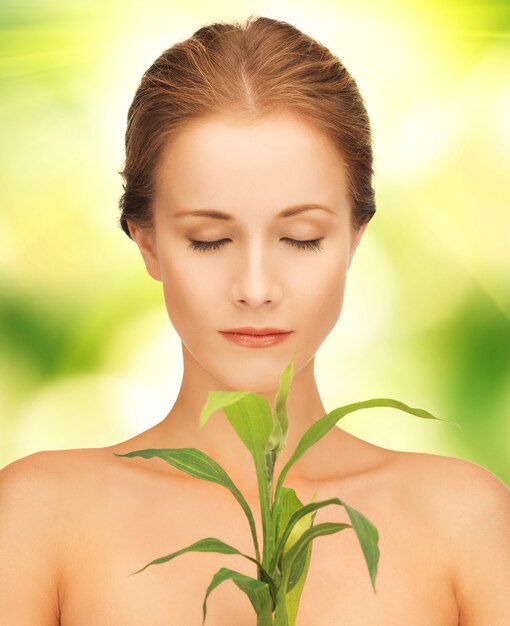 photo en gros plan d'une femme avec une pousse verte.