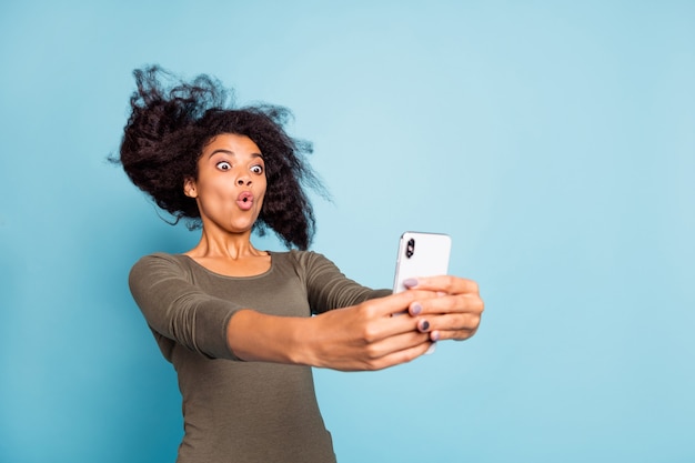 La photo en gros plan d'une fille afro-américaine funky drôle se sentir impressionné expression imaginer qu'elle sur des montagnes russes prendre selfie pour blog blogueur influenceur porter style tenue isolé mur de couleur bleu