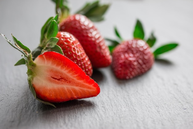 Photo en gros plan de fraises rouges fraîches posées sur une table en pierre noire