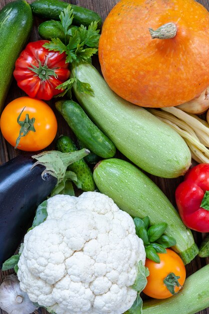 Photo en gros plan de légumes et de verdure biologiques frais de la ferme. Vue de dessus sur fond de bois