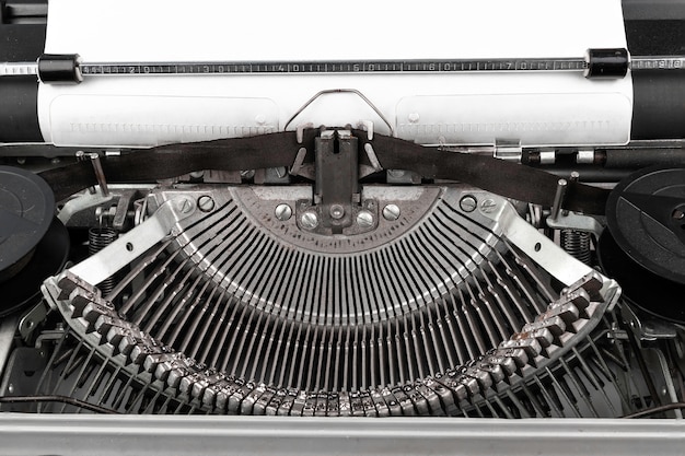 Photo en gros plan d'une machine à écrire vintage avec une feuille de papier vide
