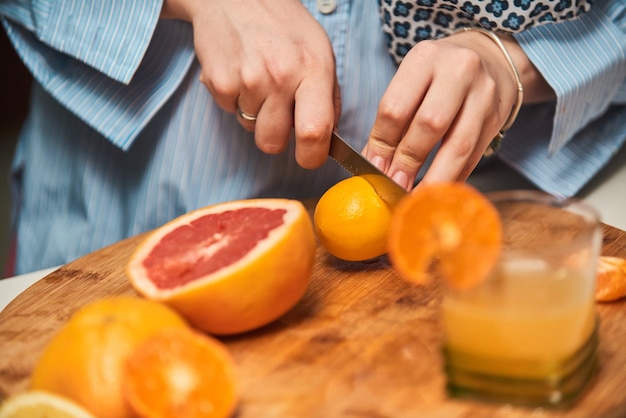 Une photo en gros plan d'une main de femme coupant et préparant des fruits pour faire un smoothie sain Le concept d'un mode de vie sain