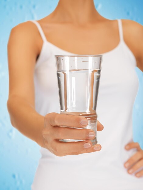 Photo gros plan de mains de femme tenant un verre d'eau