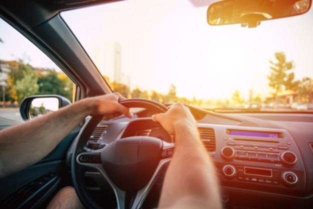 La photo en gros plan des mains des hommes pendant qu'il dirige le volant de la voiture