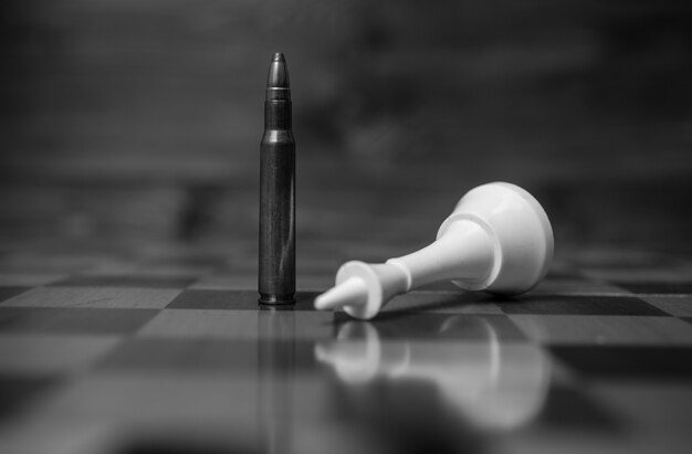 La photo en gros plan en noir et blanc de la balle gagne le jeu d'échecs. Concept de puissance des armes à feu