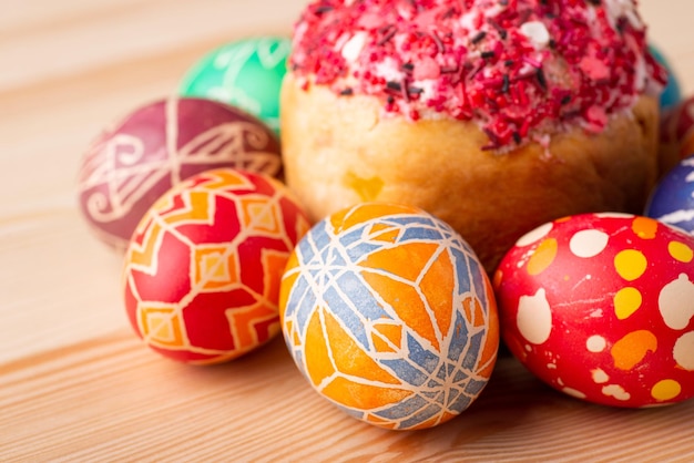 Photo en gros plan d'oeufs de Pâques peints près du pain de Pâques sur une table en bois. Célébration traditionnelle de Pâques en Ukraine