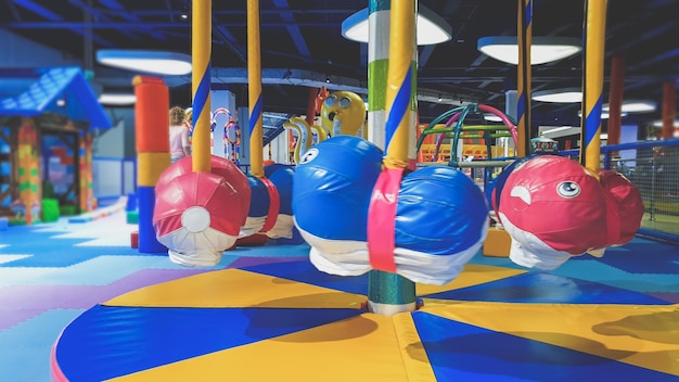 Photo en gros plan d'un petit carrousel coloré pour les petits enfants recouvert de tapis saoft pour la sécurité des enfants sur l'aire de jeux du parc d'attractions